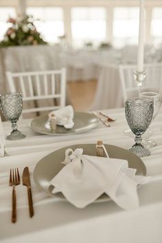 the table is set with white linens and silverware