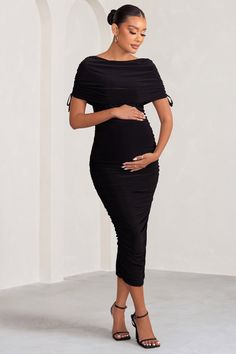 Showcase your blossoming curves in the fresh season ahead wearing our black maternity dress, Roxanne. Designed in a bodycon silhouette with a high Bardot neckline and bow-accented sleeves, this ruched midi dress is both comfortable and contouring as it's crafted in our signature double-lined jersey. Let your gorgeous new figure shine as you style this baby shower option with understated accents. Features- Premium stretch jersey- Fully ruched- High Bardot neckline- Wide short sleeves- Lace bow embellishments- Bodycon fit- Invisible zip closure- Split hemline- Midi lengthSizing & Fit Model is 5’.8.5 and wears UK size 8 / US size 4 Product Information Designed exclusively by Club L London Double layered with good stretchPremium jersey in Black (95% Polyester, 5% Elastane)140cm total lengthSKU Black Maternity Dress, Maternity Black Dress, Bardot Neckline, Maternity Midi Dress, Black Tie Gala, Your Gorgeous, Party Dress Long Sleeve, Maxi Dress Prom, Ruched Midi Dress