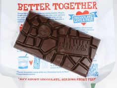 a bar of chocolate sitting on top of a piece of plastic wrapper with the words, better together