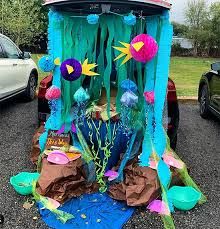 a car is decorated with paper and other things in the back yard, including an aquarium