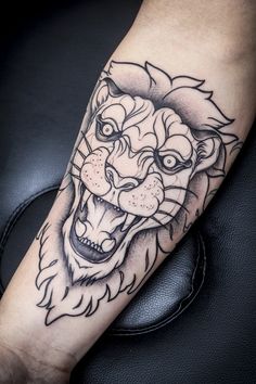 a black and white lion tattoo on the arm