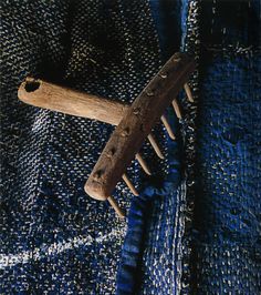 an old wooden comb sitting on top of blue fabric