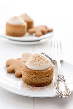 two white plates topped with desserts on top of a table next to silverware