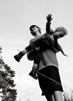 black and white photograph of two women holding a child in their arms while standing on top of a hill