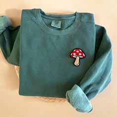 Cozy up with our Comfort Colors Mushroom Crewneck Sweatshirt this fall season and all year round! This makes the perfect gift for cottagecore and mushroom lovers! - Our sweatshirt material is super soft and high quality! ♡ - Garment-Dyed Sweatshirt (Sustainable style)  - 80% cotton, 20% polyester - All our sweatshirts run a UNISEX fit. (Both for men and women) They fit true to size. But if you like a more baggy look, we highly recommend sizing up. - These letters are embroidered iron-on patches Mushroom Shirt, Dyed Sweatshirt, Comfort Colors Sweatshirt, Sustainable Style, Fall Sweatshirt, Lovers Gift, Fall Season, Comfort Colors, Gift For Lover