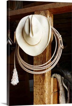 a cowboy's hat hanging on a wooden post