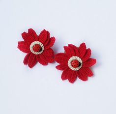 two red crocheted flower clips on white background