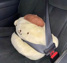 a teddy bear in the back seat of a car with a pillow on it's head