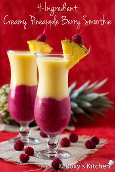 two glasses filled with fruit and ice cream on top of a red table cloth next to pine