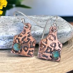 These tiny copper cattle tag earrings feature a tiny 3mm turquoise kingman stone. textured with a leopard design for a wild and unique style.  The perfect simple every day pair you need. These tiny cow tags are about the size of a dime and light enough to wear all day.  They fall about 1 inch from the ear to the bottom and go well with long or short hair styles. Simple yet elegant to add to your collection of cowgirl jewelry.  Each pair is made with a tiny stone in the corner of the earring. gen Cow Tag Earrings, Cattle Tags, Cheetah Style, Cow Tag, Leopard Design, Cowgirl Jewelry, Cow Girl, Kingman Turquoise, Copper Earrings