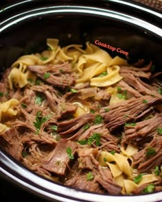 a crock pot filled with meat and noodles