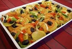 a casserole dish with olives, peppers and onions in it on a red table