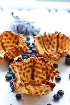 blueberries and waffles are arranged on a white surface with chocolate chips in the middle