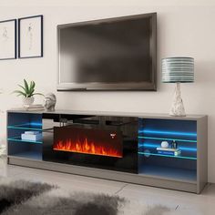 a television stand with a fire in the fireplace