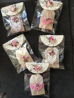 four bags with pink flowers and lace on them