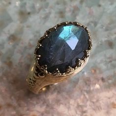 I believe A stunning crown ring with a deep blue green labradorite set in a golden brass crown bezel.(code:RK2052-1) © 2011-2018, Artisanimpact Inc. All rights reserved. *The ring in 14k rose, yellow or white gold is available in a separate listing. Construction & Dimensions: Brass, labradorite approximate width on top 12mm x 18mm band width 5mm **Please note that depending on the acidity of your skin, brass jewelry can tarnish your skin quicker than others We can make any size, including qu Royal Ring, Green Labradorite, Ring Green Stone, Royal Rings, Ring Crown, Green Stone Ring, Green Stone Rings, Crown Ring, Labradorite Ring