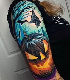 a woman with a tattoo on her arm has a pumpkin and bats in the background