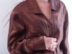 Vintage shiny brown shirt. 90's sheen brown bronze blouse. Fits like a M. Made in spain. Measurements lying flat: Bust: Waist: Length: Very good condition. Formal Brown Button-up Top, Formal Brown Spring Shirt, Formal Brown Shirt For Spring, Brown Long Sleeve Party Blouse, Fitted Brown Shirt For Formal Occasions, Brown Silk Long Sleeve Tops, Brown Long Sleeve Blouse For Party, Long Sleeve Sheen Blouse For Fall, Brown Silk Party Tops