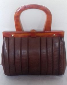 Here is a Fantastic 1940s Vintage Ladies Brown Leather handbag - Purse with Lucite handles, 2 lucite handles this beautiful vintage handbag / Purse.  The Lucite is marked in the corner Made in France.  Also this beautiful bag / purse has gold metal Screws to attach this bag / purse it is a Fantastic Vintage item which is a true Vintage Treasure the handle and clasp are all Lucite while the other part of this beautiful vintage handbag is brown leather and also is lined inside with 2 slip pockets. Vintage Double Handle Satchel For Daily Use, Vintage Brown Bag With Leather Handles, Retro Formal Satchel With Detachable Handle, Retro Satchel With Leather Handles, Vintage Brown Shoulder Bag For Formal Occasions, Vintage Formal Satchel With Double Handle, Retro Evening Satchel With Detachable Handle, Retro Satchel With Detachable Handle For Formal Use, Vintage Shoulder Bag With Leather Handles