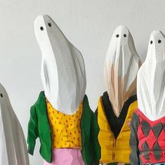 three paper dolls are standing next to each other in front of a white wall and one is looking at the camera