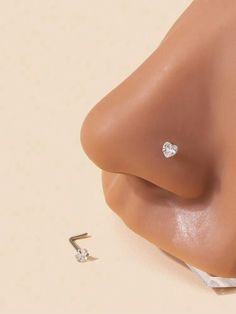 a close up view of a nose with an earring attached to the end of it