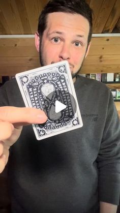 a man holding up a video playing card in front of his face and pointing to the camera