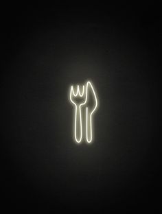 a neon sign that is lit up in the dark with a fork and knife on it