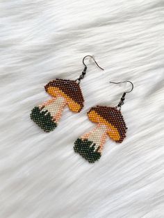 Step into a whimsical world with these hand beaded mushroom earrings! These earrings are carefully crafted with love and attention to detail, featuring a charming mushroom design will add a touch of magic to your style. Whether you're a nature enthusiast, a boho babe, or simply love unique accessories, these earrings are perfect for you. Each bead is hand selected and meticulously woven to create these adorable mushrooms. Wear them to festivals, parties, or to brighten up your everyday look.  *Features: set of two (2) nickel free fish-hook style earring with rubber backing *Hand beaded  *High quality materials *Measures approximately 1.75"X1.5" Let's get social! Follow us on our social media pages for behind the scenes looks, new item launch dates, and more. Facebook: www.Facebook.com/hipp Cute Handmade Mushroom Earrings, Cute Handmade Mushroom-shaped Earrings, Handmade Cute Mushroom Earrings, Whimsical Adjustable Beaded Earrings, Whimsical Adjustable Beaded Dangle Earrings, Cute Handmade Adjustable Beaded Earrings, Handmade Whimsical Beaded Drop Earrings, Whimsical Handmade Beaded Dangle Earrings, Whimsical Handmade Beaded Drop Earrings