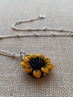 Sunflower Artisan Lampwork Bead Pendant and Sterling Silver Chain Necklace.   The photographs are an example of the pendant that you will receive, as no 2 beads are exactly the same, however all are gorgeous =) This joyful creation is simple and beautiful.  Perfect for everyday wear to add that summer sunshine happiness vibe to your day. Equally an elegant touch for special occasions as it is literally like wearing a smile.  Although this is the type of purchase you would love to keep, it would Yellow Beaded Flower Necklace As Gift, Yellow Beaded Flower Necklace Gift, Yellow Beaded Flower Necklace For Gift, Yellow Flower Necklaces For Jewelry Making, Gift Jewelry With Flower Charm In Czech Glass, Gift Jewelry With Flower Charm And Czech Glass, Round Beads Jewelry With Flower Charm For Gift, Flower Charm Jewelry With Round Beads For Gift, Handmade Czech Glass Necklace With Round Pendant