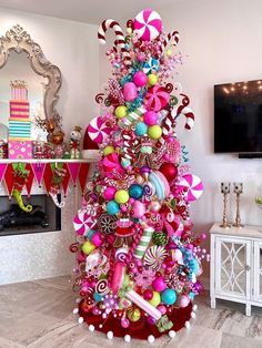 a brightly colored christmas tree with candy and candies on it in a living room