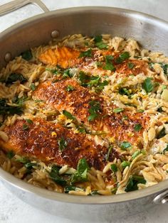 a pan filled with pasta and vegetables on top of a table