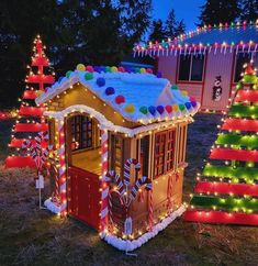 a house is decorated with christmas lights and candy canes in front of a tree