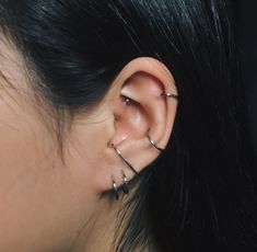 a close up of a person's ear with two piercings on it and one behind the ear