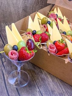 fruit and cheese appetizers in wine goblets on a wooden table, ready to be served