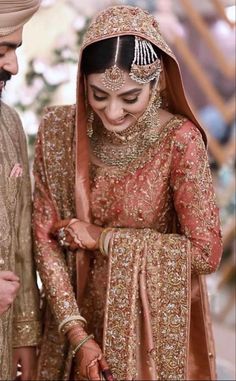 the bride and groom are looking down at each other's wedding rings in their hands