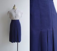 "A classic 70's piece. Navy blue polyester A-line skirt with a pleats to the front. Features a fitted high waist, belt loops & a flattering midi length. Zip & hook closure to the back. Skirt is lined. Blouse is available here: https://etsy.com/listing/96463992 Best fits an XS. Mannequin is a Size S, skirt could not be zipped fully. Waist is 12\" across / 24\" all around. Hips are 18.5\" across. Total length of 26\". Excellent vintage condition, exactly as pictured! There is a small mark Fitted Blue Bottoms With Accordion Pleats, Blue Pleated Waist Skirt For Work, Classic Blue Pleated Skirt For Spring, High Waist Retro Pleated Skirt, Fitted Blue Skirt With Pleated Hem, Vintage Blue Pleated Skirt Bottoms, Vintage Blue Pleated Skirt, Fitted Blue Pleated Workwear Skirt, Blue Pleated Waist Bottoms For Work