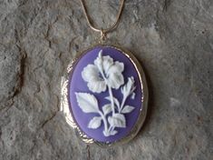 Beautiful cameo locket!!!  The cameo is a gorgeous flawless white flower on a striking lavender/purple background!!!  The locket is victorian style with beautiful scroll on the front and back about 2" long.  It can hold two photos, a treasured keepsake, or even your daily medication or vitamins!!! Pass down from generation to generation!!! The chain is 22"  1.2mm .925 plated snake chain with a lobster claw clasp!!! Perfect  for Brides or Bridal parties.  Makes a unique memorable gift for any occ Purple Flower-shaped Formal Jewelry, Purple Flower Necklace For Wedding, Lavender Purple Background, Cameo Locket, Bridal Parties, Cameo Jewelry, Purple Background, Lavender Purple, Purple Backgrounds