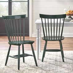 two green chairs sitting on top of a rug