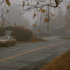 a car driving down a road in the rain