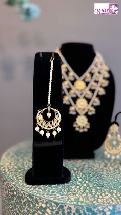 Indulge in luxury with our Pearl Kundan Polki Satlada Style set, complete with a stunning maang tikka and delicate chandbali earrings. Handcrafted with exquisite pearl and Kundan stones, this set exudes elegance and sophistication, making it a must-have for any special occasion. Elevate your look with this exclusive piece. Hand Set Bollywood Style Chandbalis For Ceremonial Occasions, Ceremonial Chandbali Earrings With Latkans, Chandbali Kundan Necklace For Wedding, Bollywood Style Chandbalis For Ceremonial Occasions, Kundan Chandbali Bridal Necklace With Latkans, Ceremonial Chandbali Earrings With Tilla, Bollywood Style Chandbali Tikka With Intricate Design, Bollywood Chandbali Tikka For Ceremonial Occasions, Ceremonial Tilla Chandbalis