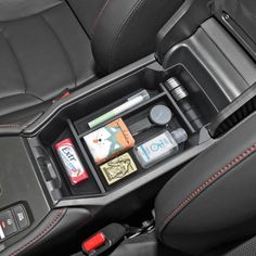 the interior of a car with various items in it's center console and cup holder