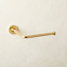 a gold toilet roll holder on a white wall