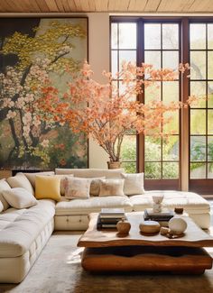 a living room filled with furniture and a painting on the wall above it's windows