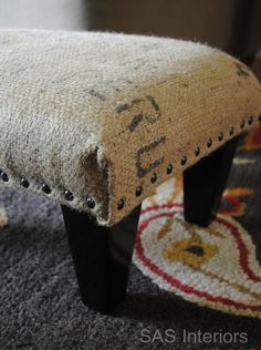 an upholstered foot rest on the floor in front of a carpeted area