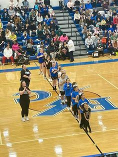 the cheerleaders are lined up on the basketball court