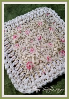 a crocheted square with pink flowers on it