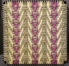 a close up of a woven basket with pink and white strips on it's sides