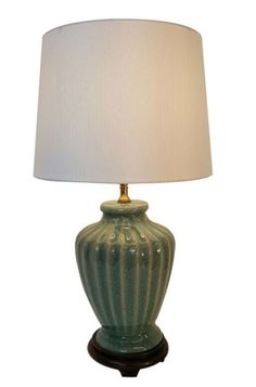 a green lamp with a white shade on it