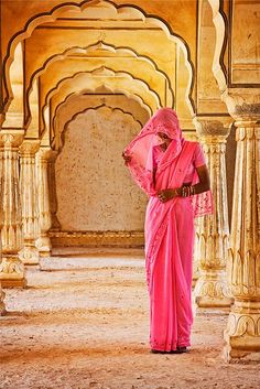 a woman in pink standing next to a monkey