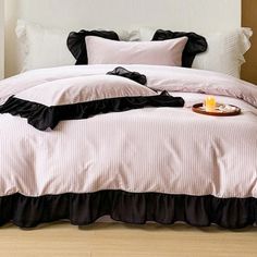 a bed with black ruffled bedspread and pillows